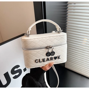 Vue détaillée du mini sac blanc matelassé avec logo en métal et poignée supérieure