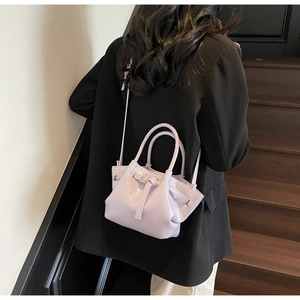 Sac seau violet clair en similicuir avec poignées porté à l'épaule par le mannequin