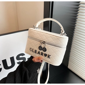 Gros plan du sac en cuir matelassé blanc avec logo métallique argenté et détail de cœur