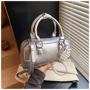 Detail of silver metallic boston bag with crinkled texture and heart pearl charm