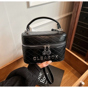 Détails du sac boîte matelassé noir avec logo en métal argenté et double zip