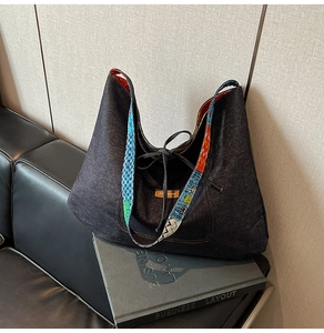 Detail of denim tote bag with colorful ethnic woven strap and drawstring closure