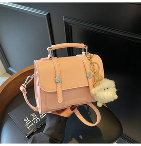 Pink PU leather crossbody bag with silver hardware and cute plush monster charm