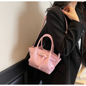 Vue détaillée du sac à main rose en cuir verni avec boucle argentée et poignée ronde