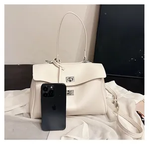 Cream tote bag with silver turn-lock and adjustable strap shown next to a smartphone