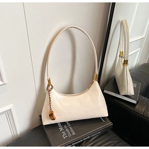 Detail der cremeweißen Leder-Schultertasche mit eleganter Goldkette und Reißverschluss