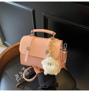 Pink crossbody square bag with silver buckle and cute white plush monster keychain