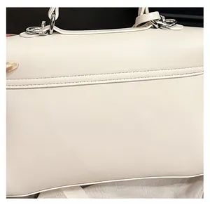 Detailed close-up of cream white leather tote bag featuring premium double stitching and silver ring