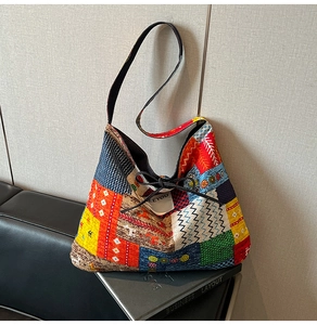 Detailed macro view of vibrant patchwork patterns and fine stitching on the denim tote bag