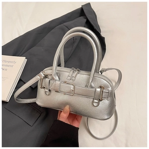 Detail of silver metallic shell bag with decorative buckles and dual zipper closure