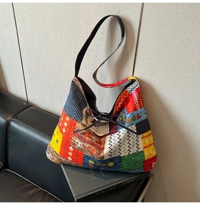 Detail of colorful patchwork denim hobo bag with tie closure and wide black strap