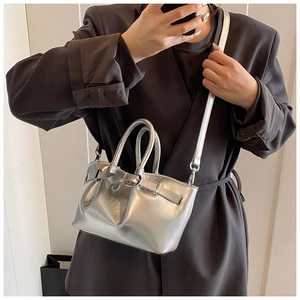 Detail of silver metallic mini bucket bag with round handles and detachable strap