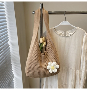 Détail d'un sac cabas en crochet beige avec marguerite blanche et texture ajourée