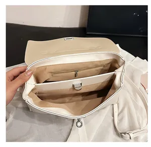 Detail view of the white leather tote bag interior with multiple functional compartments