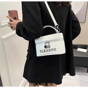 Détail du sac à main matelassé blanc avec logo métallique et texture en cuir