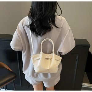 Gros plan d'un sac seau blanc crème brillant avec design plissé et boucle décorative