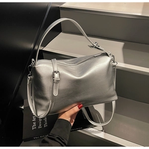 Detail of silver metallic leather handbag showing its textured finish and zippers