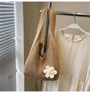 Détail du tissage et fleur de marguerite 3D sur un sac fourre-tout en crochet beige