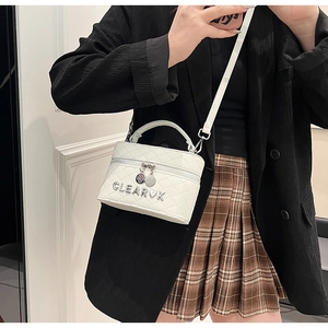 Gros plan sur le mini sac bandoulière blanc matelassé avec lettrage argenté chic