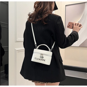 Détail du sac bandoulière blanc matelassé avec bandoulière chaîne sur un mannequin