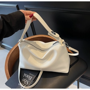 Close-up of white pleated crossbody bag showing textured synthetic leather and handle