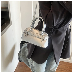 Detail of silver metallic mini bag styled with dark blazer and vintage denim jeans