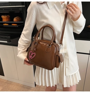 Chocolate brown vintage Boston bag with heart charm shown in a cozy lifestyle setting