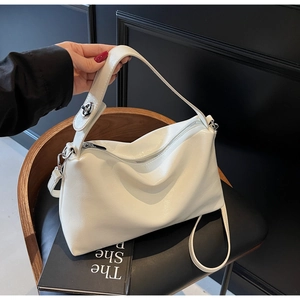 Detail of white textured leather handbag with silver metallic zipper and hardware