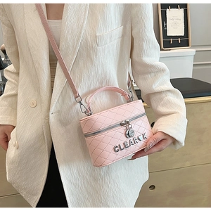 Détail du sac à bandoulière matelassé rose avec fermeture éclair argentée et chaîne
