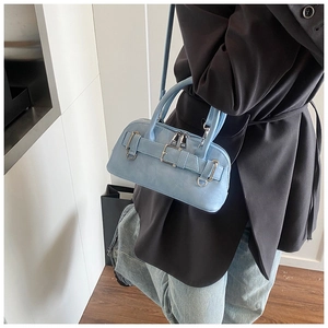 Close-up of light blue leather handbag with silver polished metal buckle and belt detail
