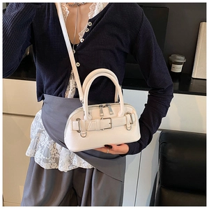 Detail of white shell handbag showing silver zippers, metal buckles and leather texture