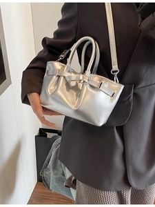 Metallic silver bucket bag with double handles and strap shown as a crossbody bag