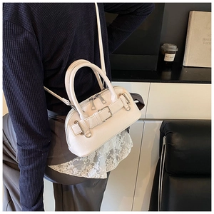 Chic cream leather shell bag with buckle strap and silver hardware on a crossbody strap