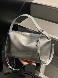 Silver leather boston bag with top handle and adjustable shoulder strap on stairs
