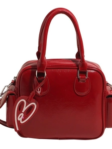 Red patent leather Boston tote bag with twin handles and heart charm details