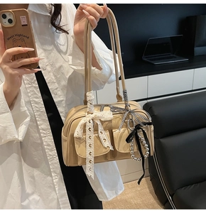 Dettaglio della borsa Boston beige con fiocchi di pizzo e nastri a quadretti neri