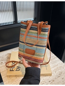 Chic multi-color striped straw bucket bag with leather strap and top handle design