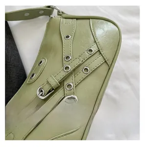 Detail of avocado green shoulder bag featuring silver metal eyelets and buckled straps
