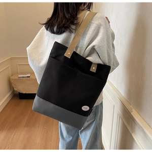 Detail of canvas tote bag with multi-pockets and cotton strap shown on female model