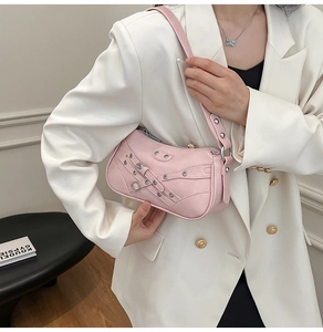 Pink punk motor style shoulder bag with buckle details and metal rivets on model