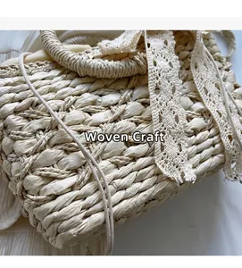 Nahaufnahme der beigen Stroh-Handtasche mit grober Webstruktur und Spitzenband-Details