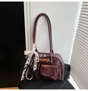 Detalle de bolso vintage burdeos con bolsillos dobles y lazo de encaje elegante
