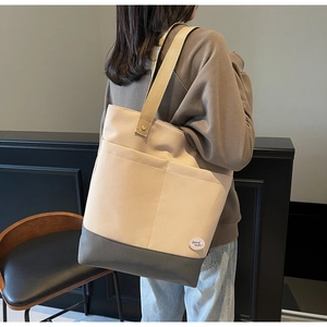 Detail of canvas tote bag with front pockets and pink good luck patch for daily commute