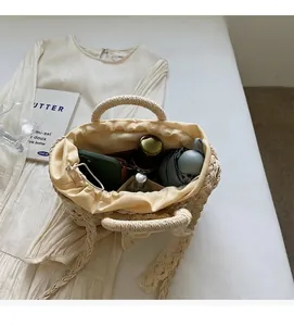 Draufsicht auf eine geräumige Strohtasche mit Kordelzug-Innenfutter auf sommerlichem Kleid