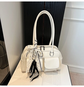 Detalle del bolso Boston blanco crema con bolsillos frontales y cinta de cuadros