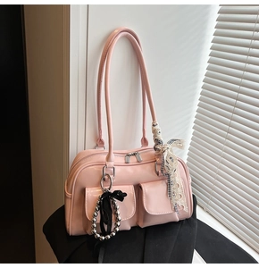 Detalle de bolso Boston rosa claro con bolsillos frontales, cuentas plata y lazo encaje