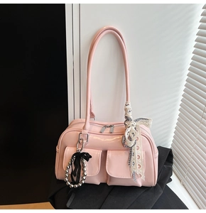 Dettaglio della borsa Boston rosa lucida con tasca laterale e fiocco in pizzo