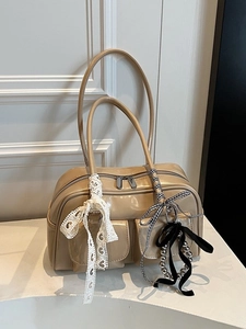 Bolso de hombro color albaricoque brillante con bolsillos y lazo sobre blanco