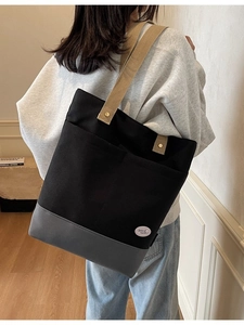 Minimalist canvas tote bag with contrast stitching and branded lucky patch on back