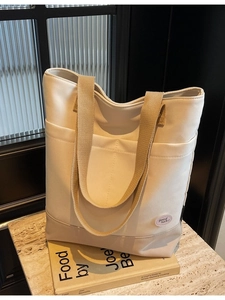 Minimalist canvas tote bag with contrast base and double front pockets for daily commute